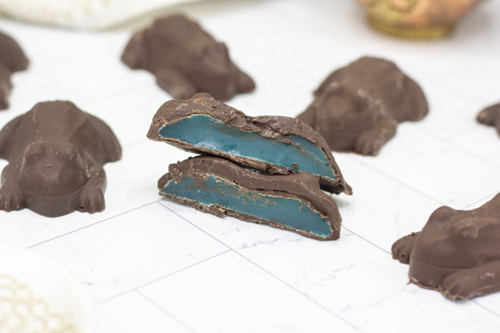 Blue raspberry lemonade jellied chocolate frog cut amidst other chocolate frogs