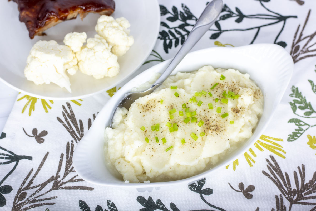 Serving dish of loaded cauliflower mash with serving spoon