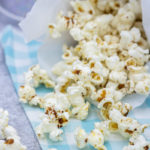 brown butter miso popcorn spilling on a blue checked cloth