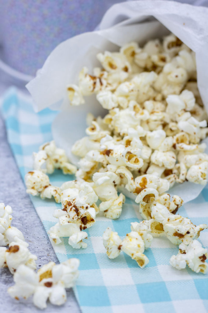 brown butter miso popcorn spilling on a blue checked cloth