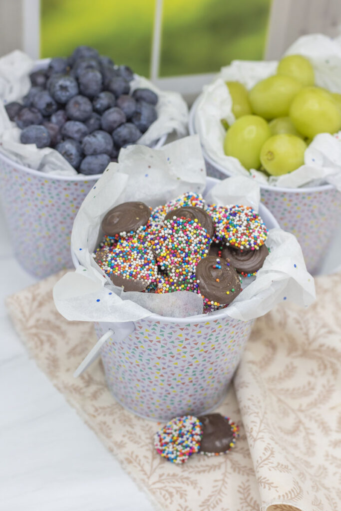 Assorted festive buckets of fruit and rainbow nonpareils