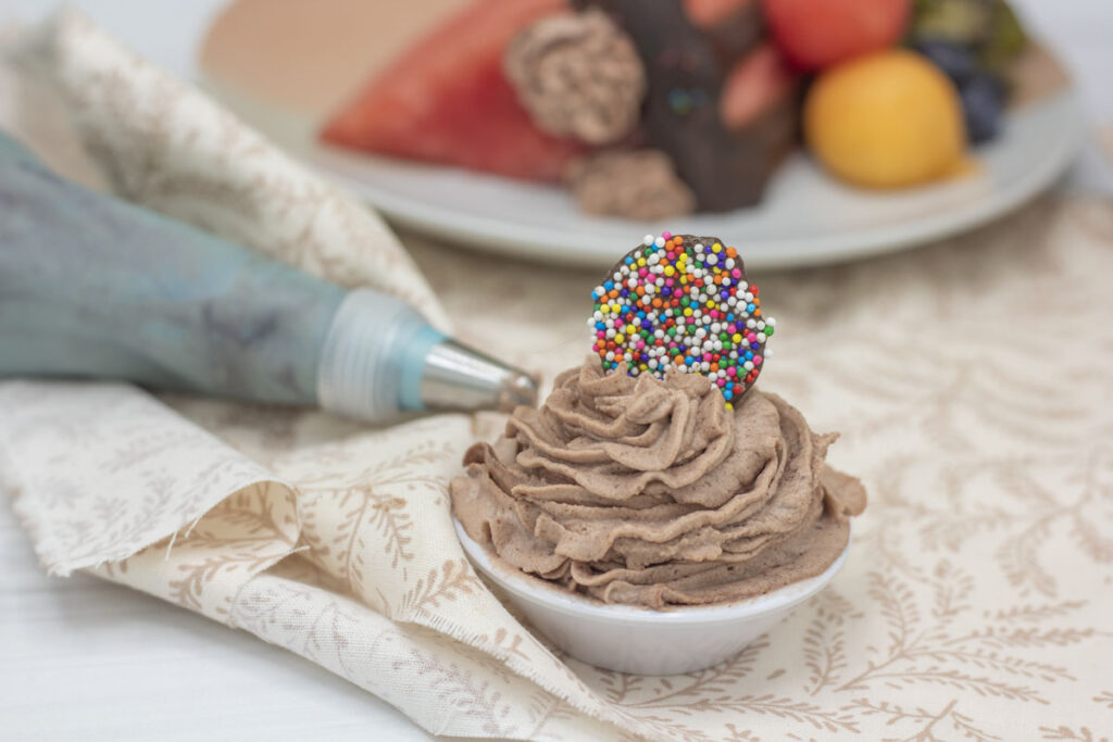 Homemade nonpareil in a bowl of frosting