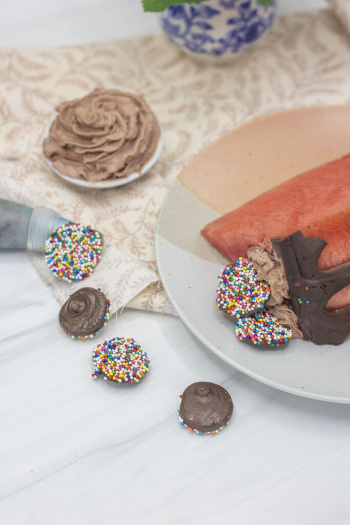 a plate of watermelon cake with assorted nonpareils and frosting