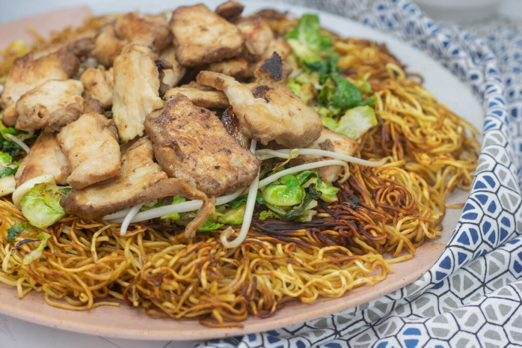 Plate of chicken over fried noodles