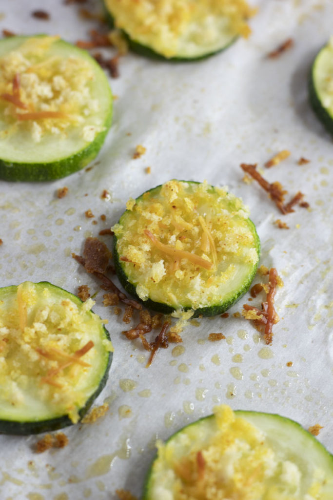 parmesan zucchini on a sheetpan with crispy cheese around it