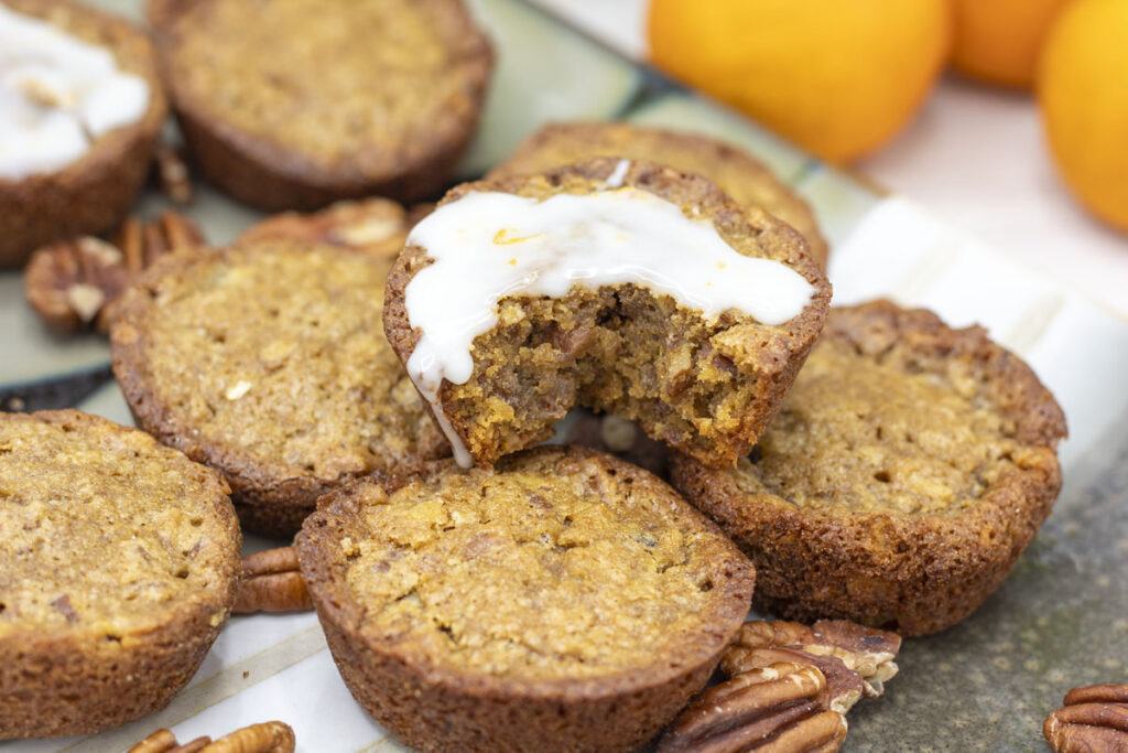 An iced pecan pie muffin with a bite taken out