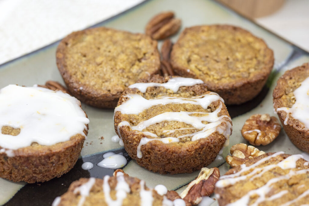 a group of nut muffins with white frosting on them