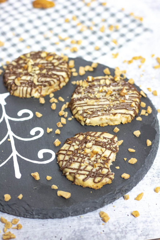 closeup of pecan toffee cookies with toffee bits sprinkled around