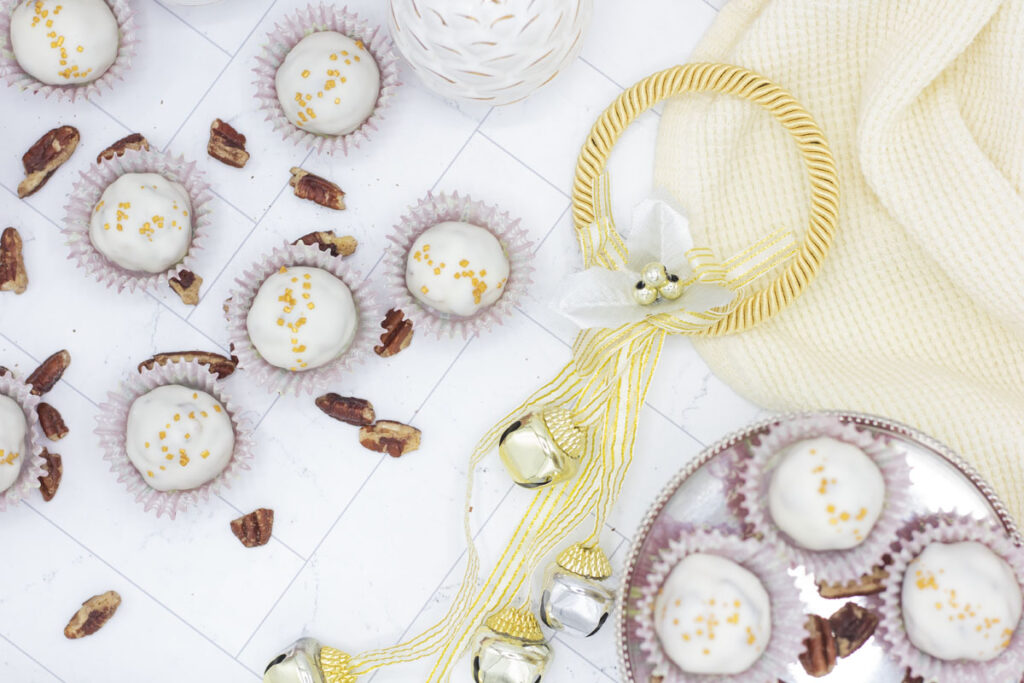 Pecan pie truffles scattered amongst holiday decor and pecans