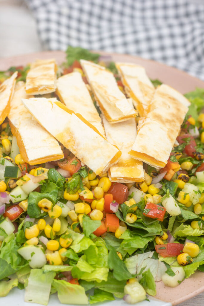Strips of cheese quesadilla on corn salsa salad
