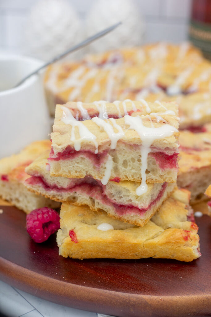 Sweet glaze dripping down over raspberry focaccia