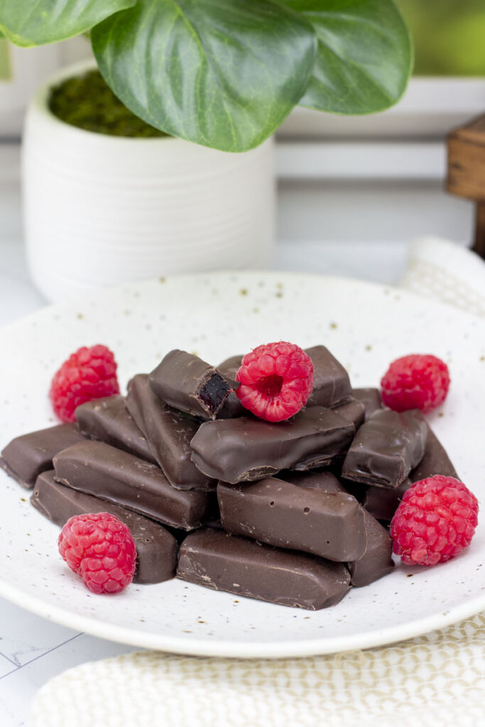 Raspberry jelly rings, only in straight stick form piled high in a bowl with raspberries