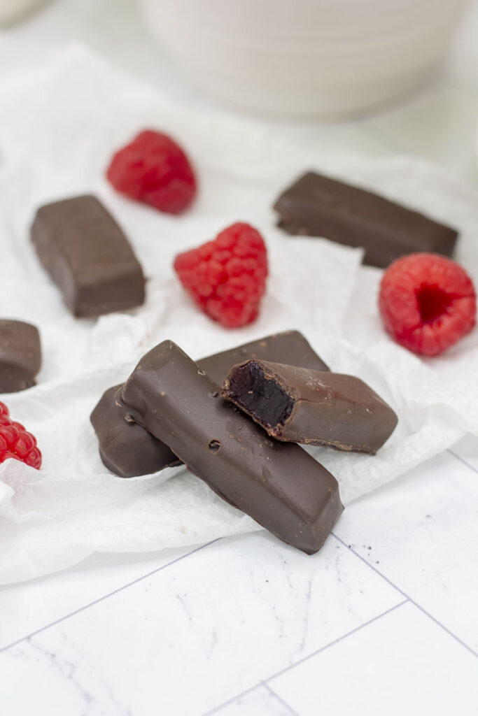 Raspberry jelly stick with a bite taken out of a stick at one end