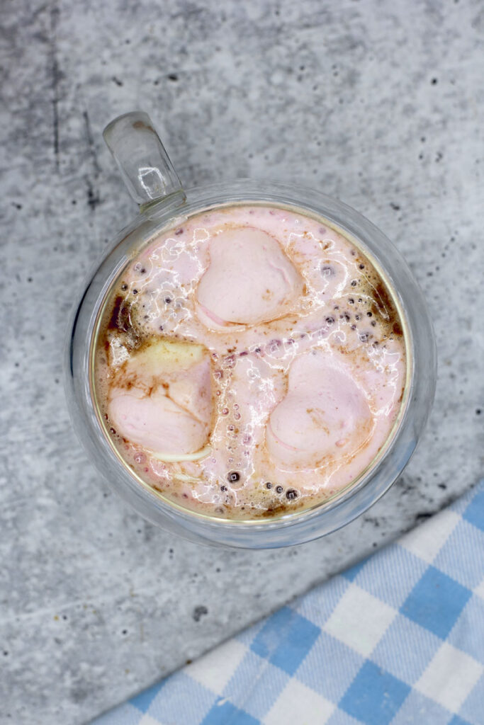 Heart shaped raspberry marshmallows melting in a mug of hot chocolate