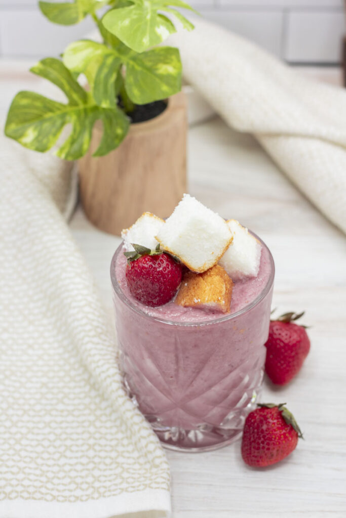 Glass of reverse strawberry shortcake piled high with cake and strawberries