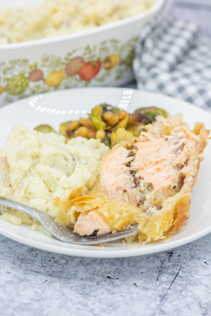 Fork digging into salmon wrapped in pastry