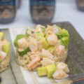 A sushi shrimp stack with ingredients toppling forward
