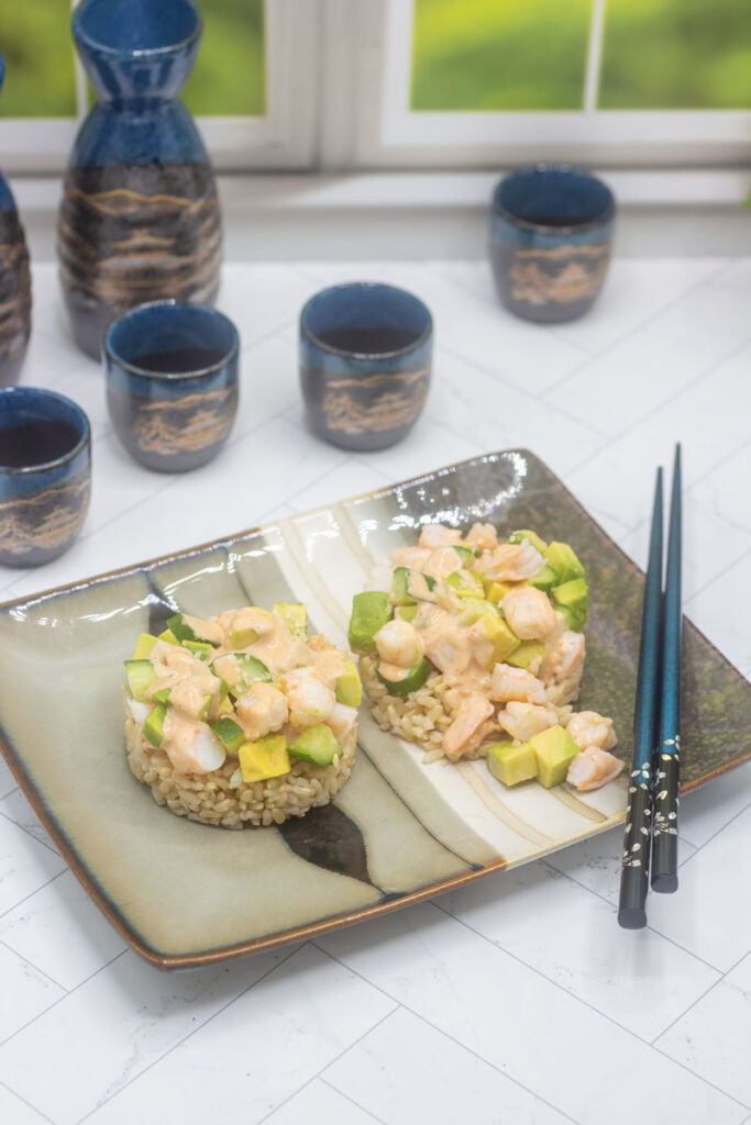 California roll shrimp stacks and sake cups in the background