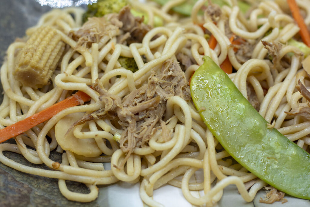 Lo mein with snow peas, pulled pork, baby corn, and carrots