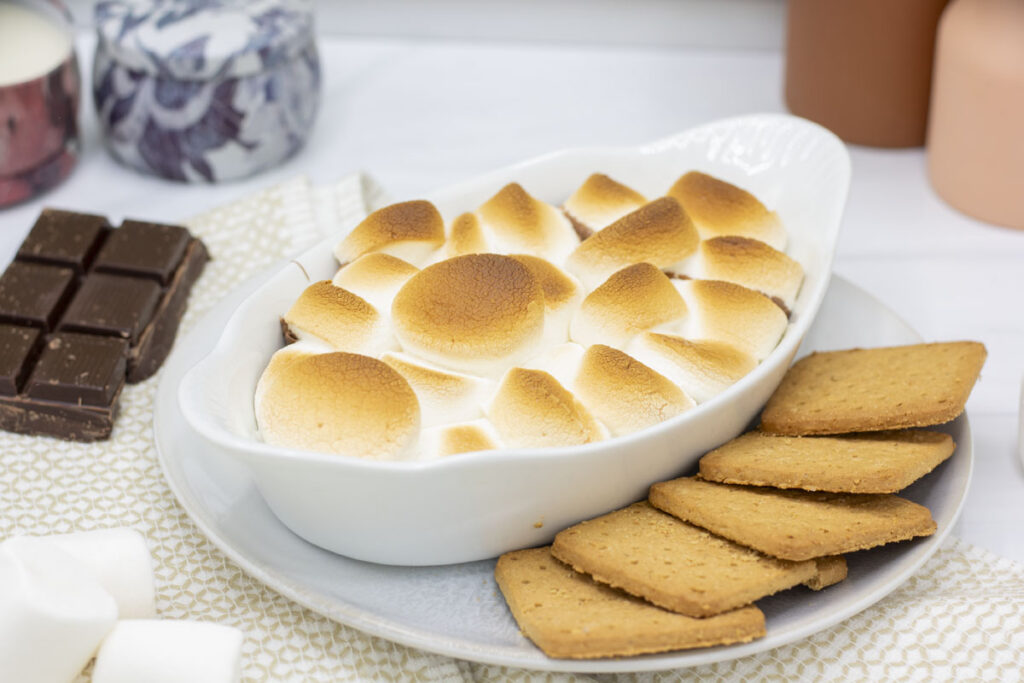 S'mores dip surrounded by chocolate, marshmallows, and graham crackers