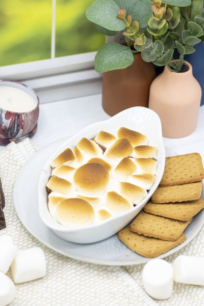 S'mores dip surrounded by chocolate, marshmallows, and graham crackers