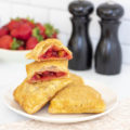 A stack of strawberry apple hand pies, one cut open