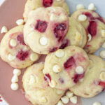 Strawberry cream cheese cookies piled on a pink and white plate