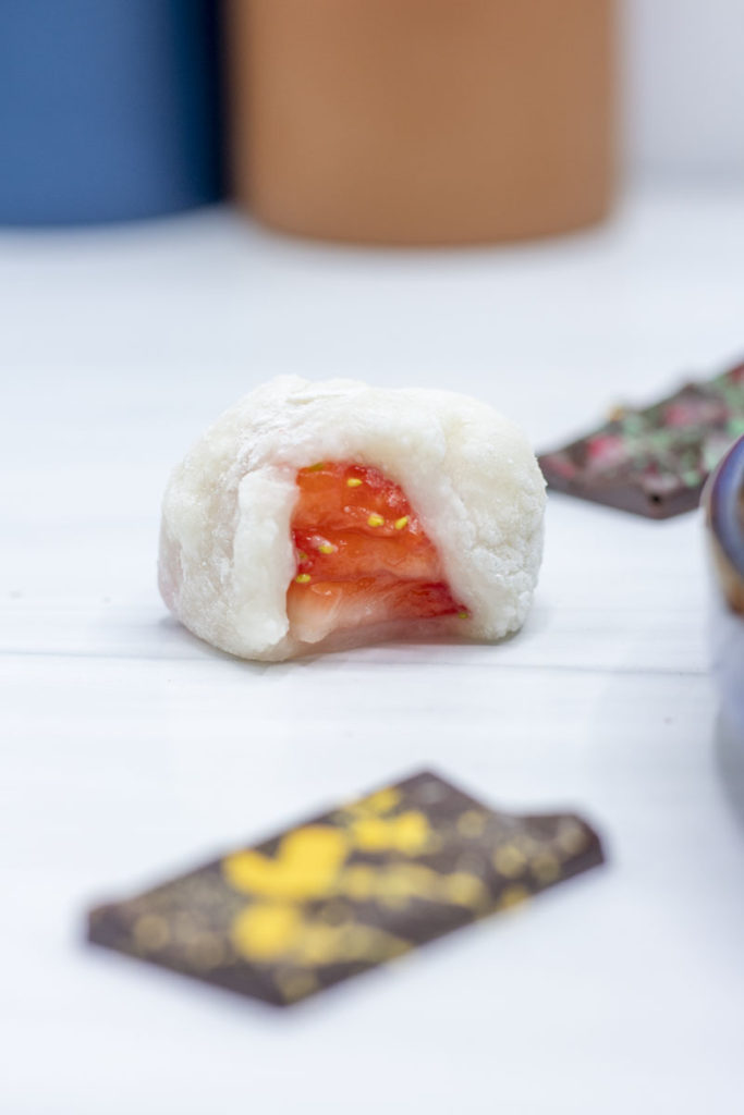 strawberry mochi with a bite taken out of it