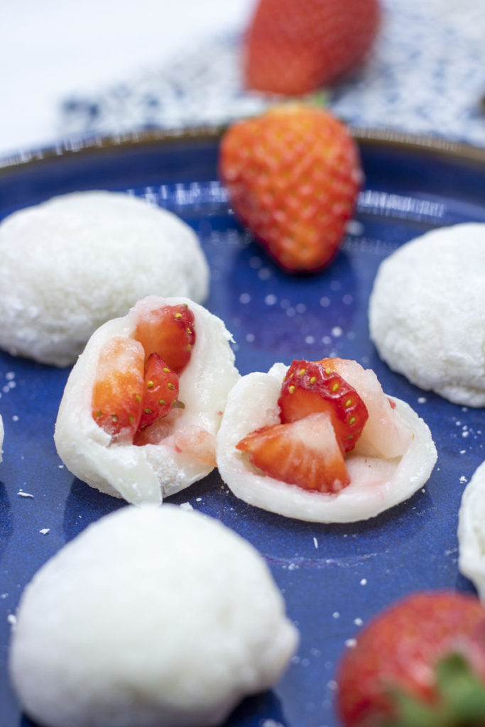 strawberry mochi cut open on a plate