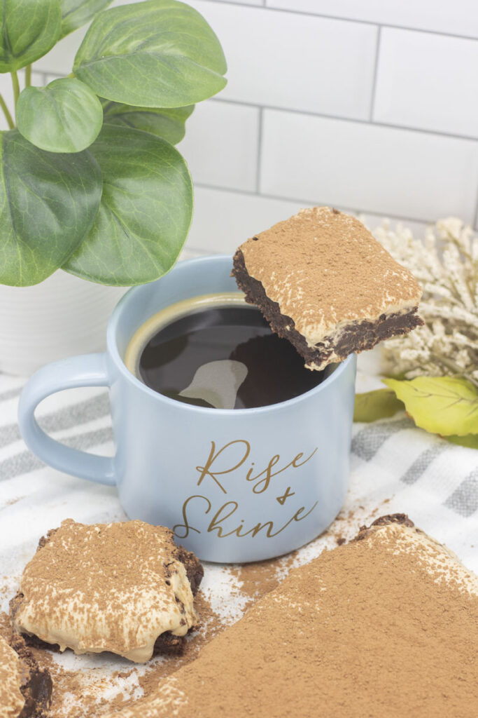 tiramisu brownie on the edge of a coffee cup reading "rise and shine"