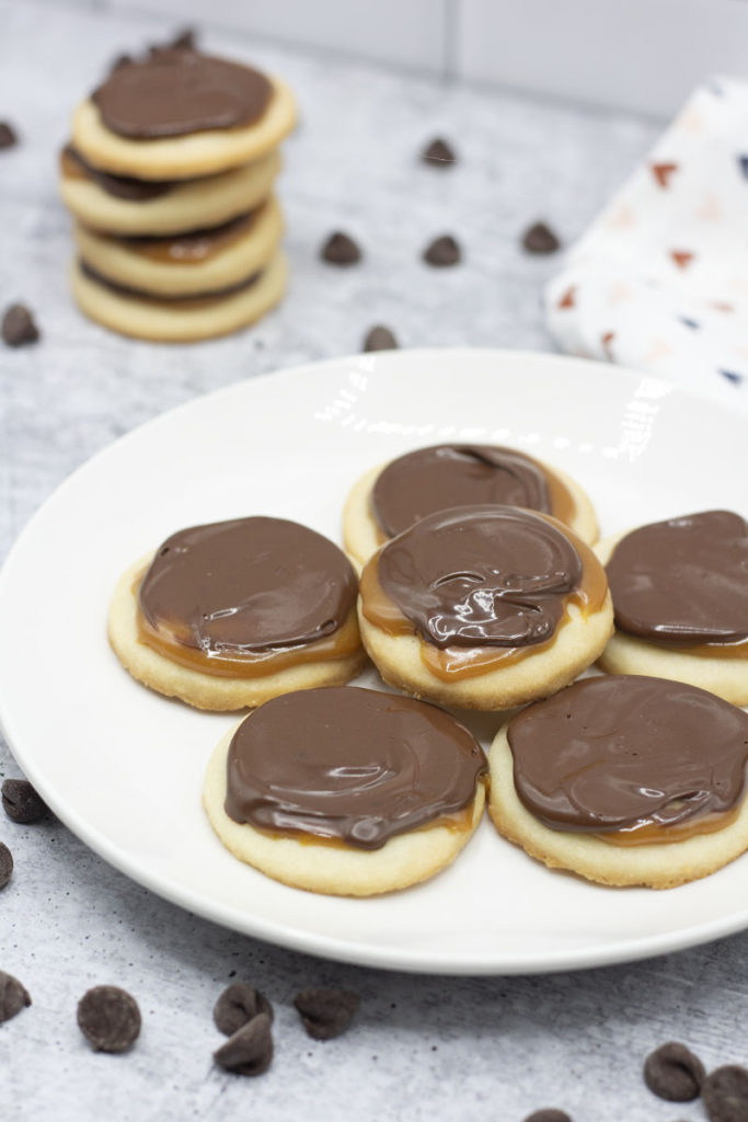 twix cookies on a plate with a stack of cookies in the background