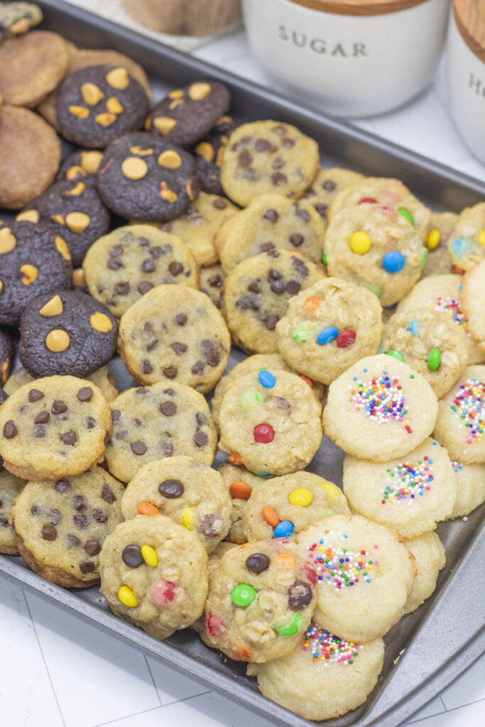 Mini cookies in assorted flavors: butter sprinkle cookies, chocolate chip cookies, monster m&m cookies, chocolate caramel chip cookies, snickerdoodle cookies, cookies and cream cookies