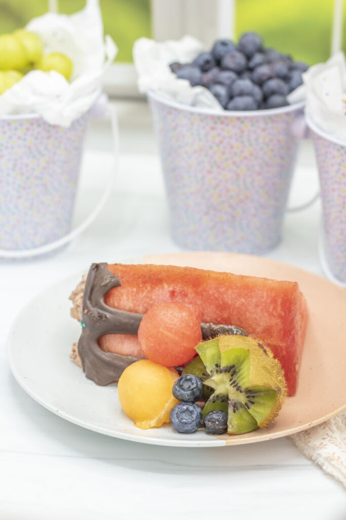 Slice of watermelon cake with fruit on a plate