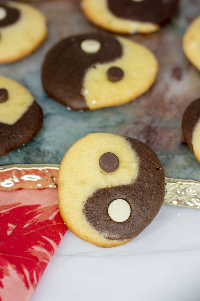 Close up of a cake cookie shaped like a yinyang with white chocolate and dark chocolate