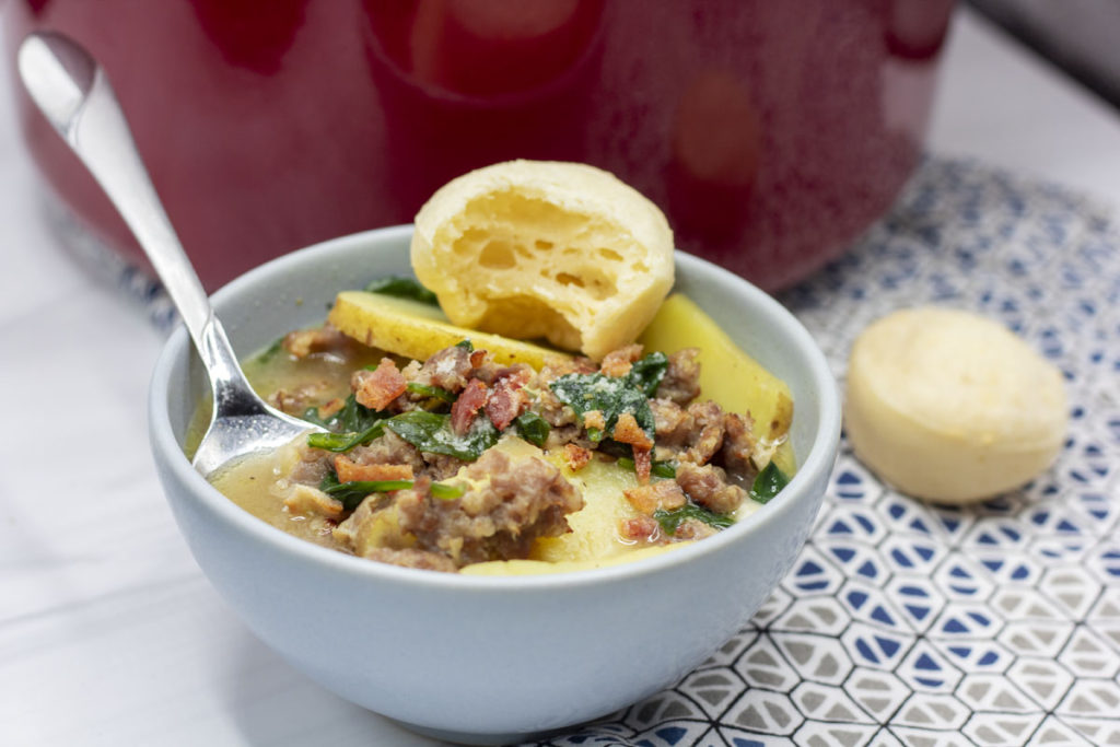 zuppa toscana with a pao de queijo perched on top