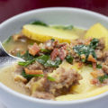 close up zuppa toscana with spoon in a bowl