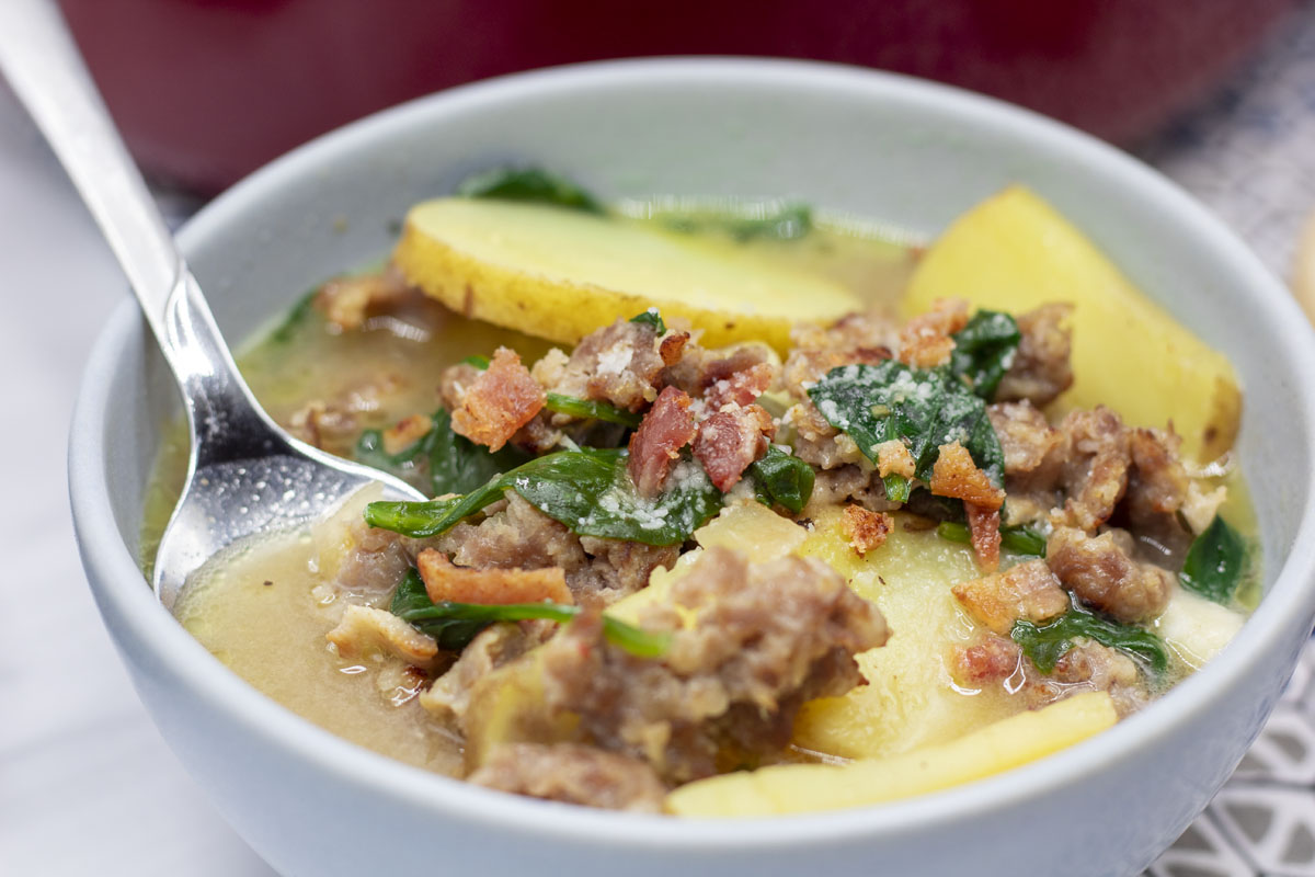 close up zuppa toscana with spoon in a bowl